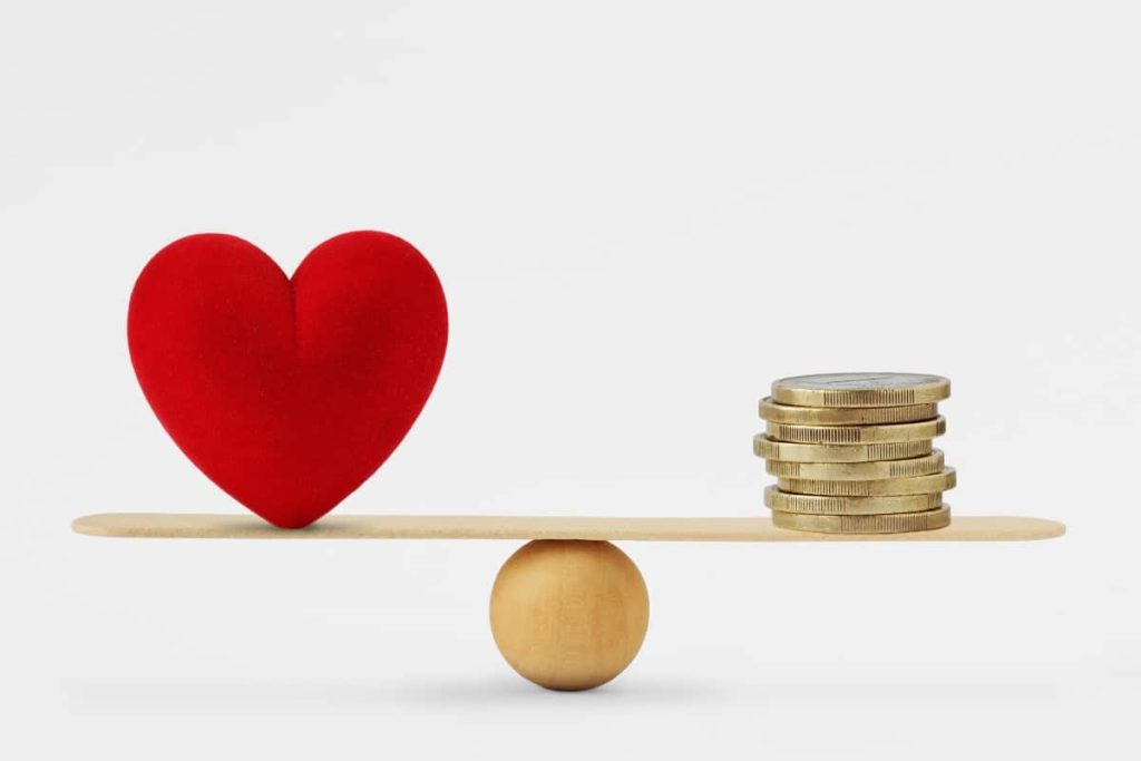 balance avec des pièces de monnaie et un coeur de l'autre coté