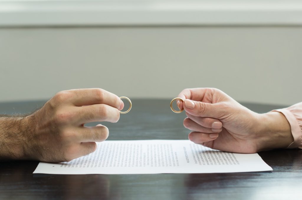 main de lhomme et de la femme qui remet les alliances après le divorce
