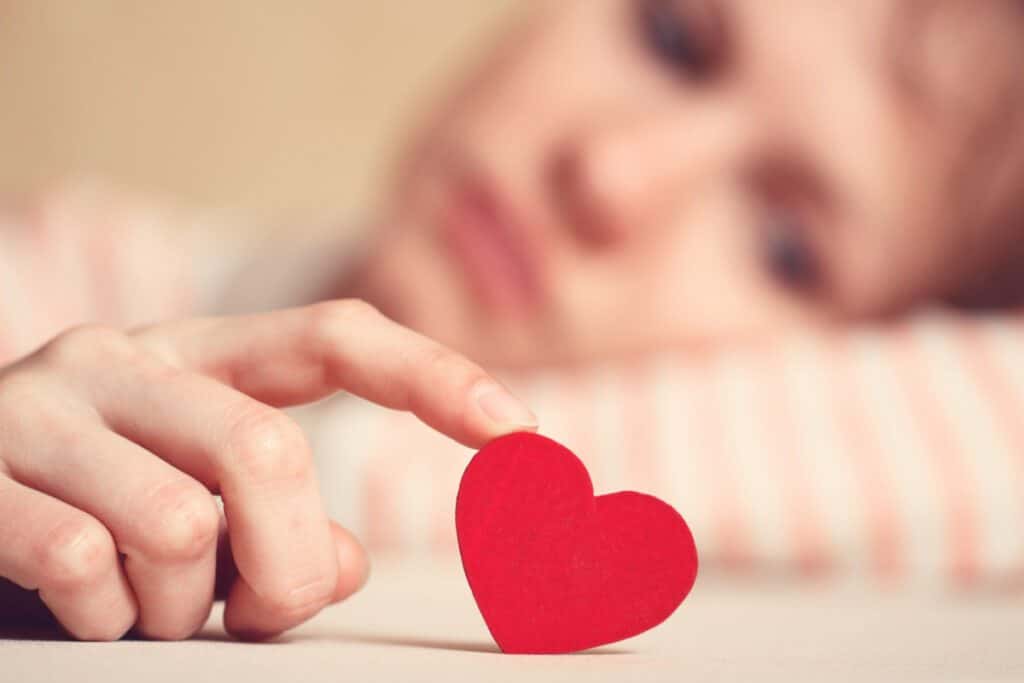 Femme célibataire tenant un petit coeur en carton