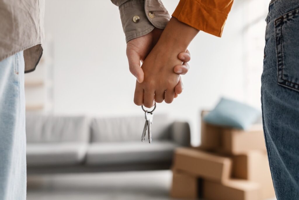 jeune couple tenant la main et la nouvelle clé de la maison