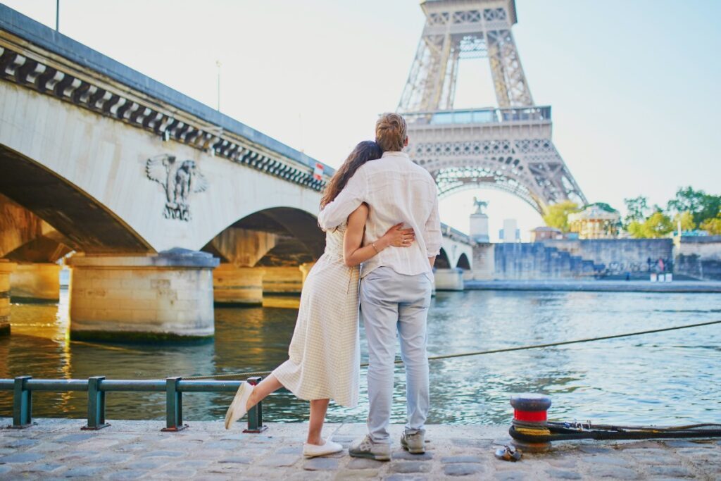 un couple se serre dans les bras après une promenade le long de la Seine