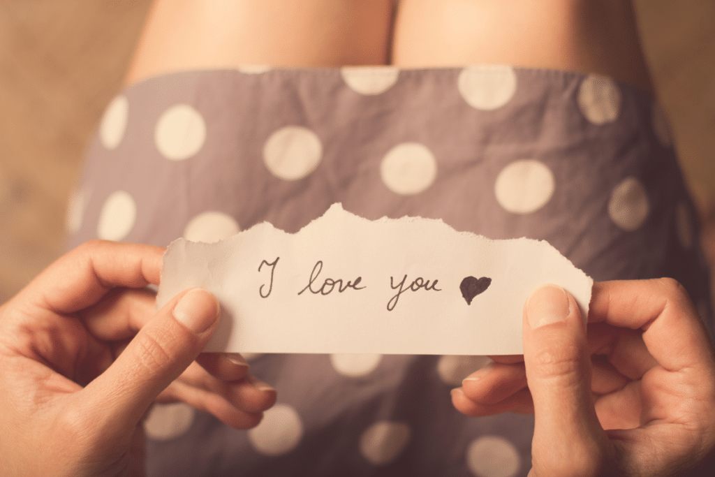 femme tenant un message sur papier avec le texte que je t'aime