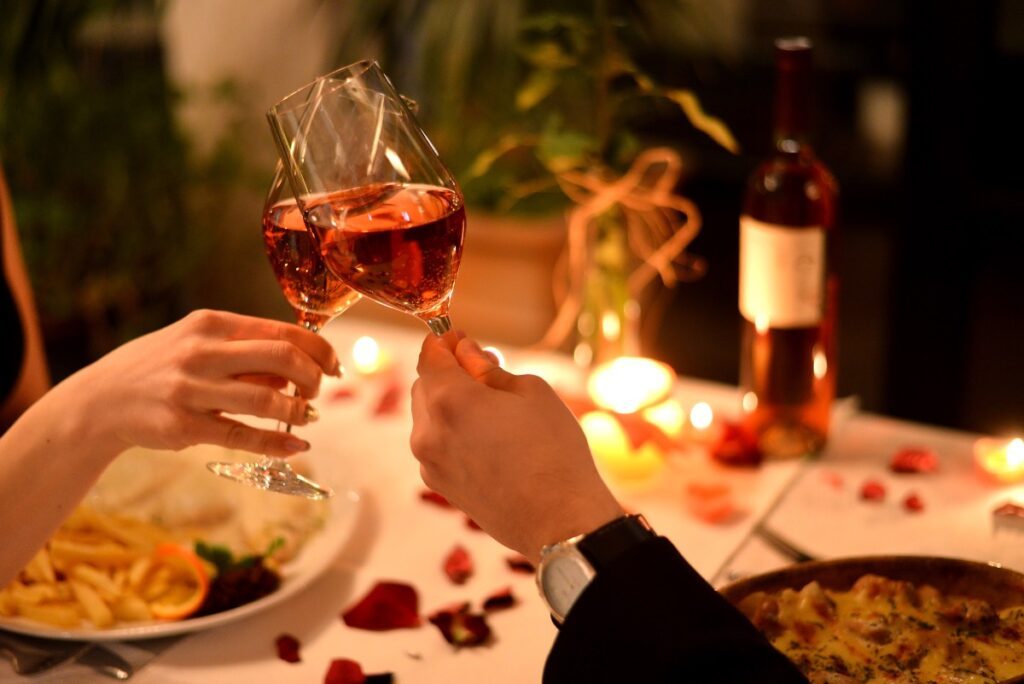 deux verres d'un couple trinquant dans un restaurant romantique à Paris