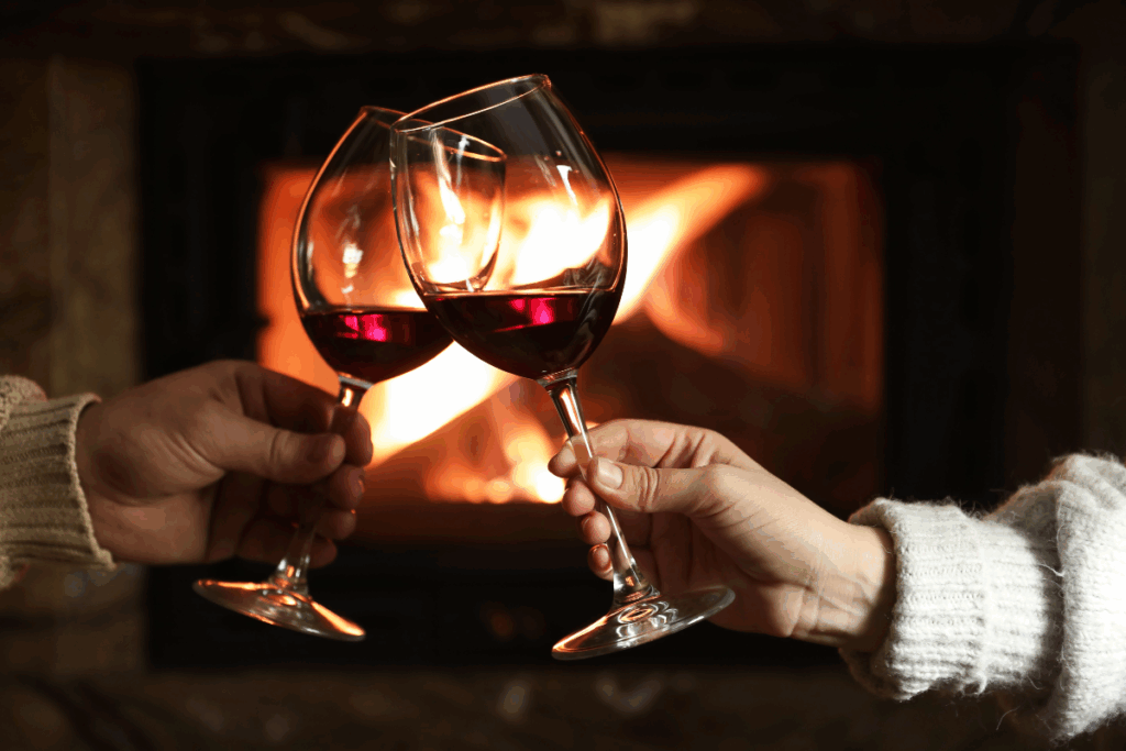 entretenir la flamme couple trinquant avec du vin près de la cheminée