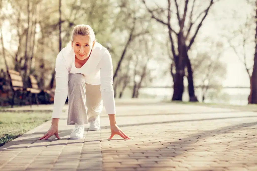Femme dans un parc, prête pour le départ d'une course.
