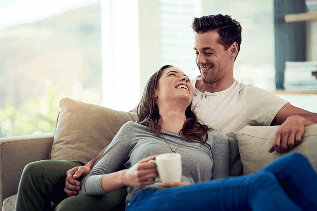 Homme et femme heureux dans une conversation amusante sur un canapé