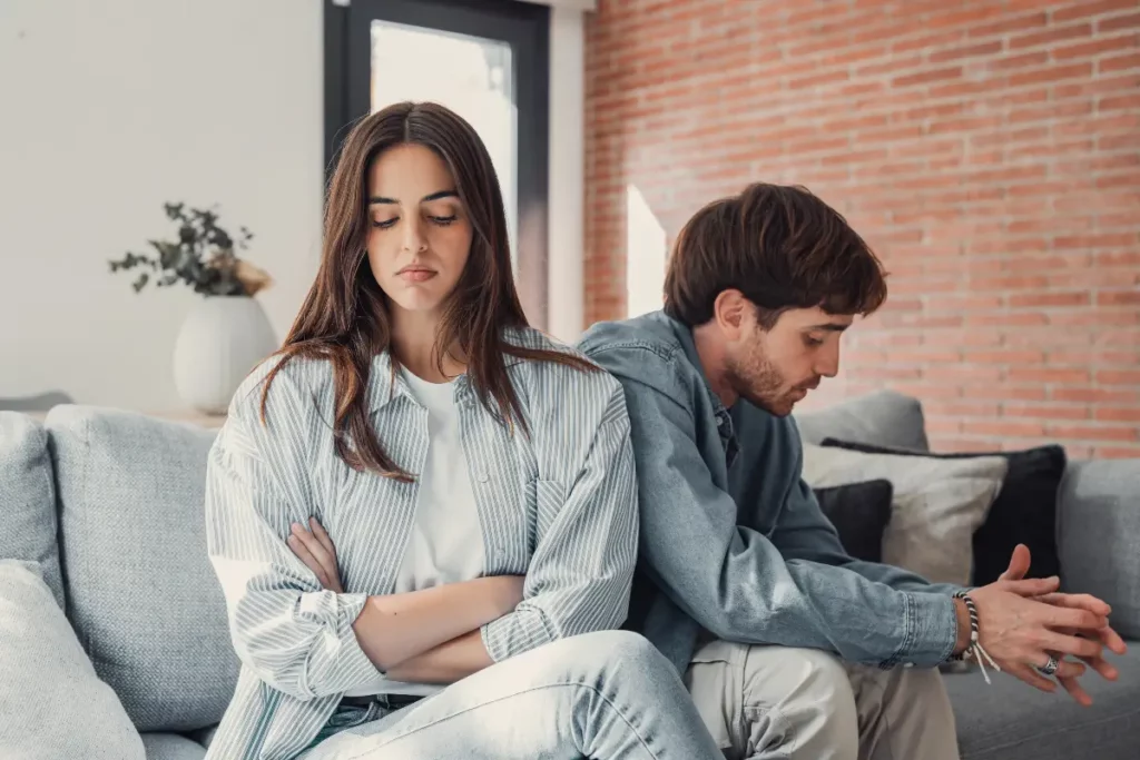 un couple qui s'est disputé, assis sur le canapé