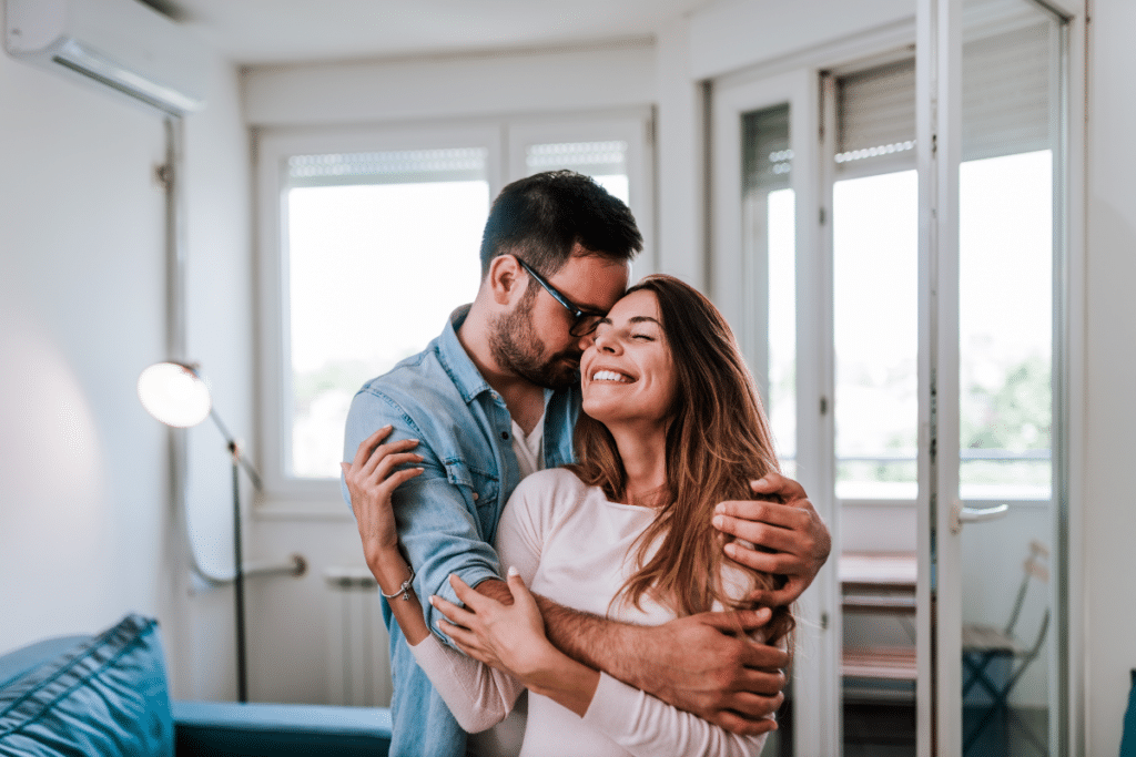 un couple heureux qui s'embrasse à l'intérieur et qui rayonne d'une solide sécurité émotionnelle dans leur relation